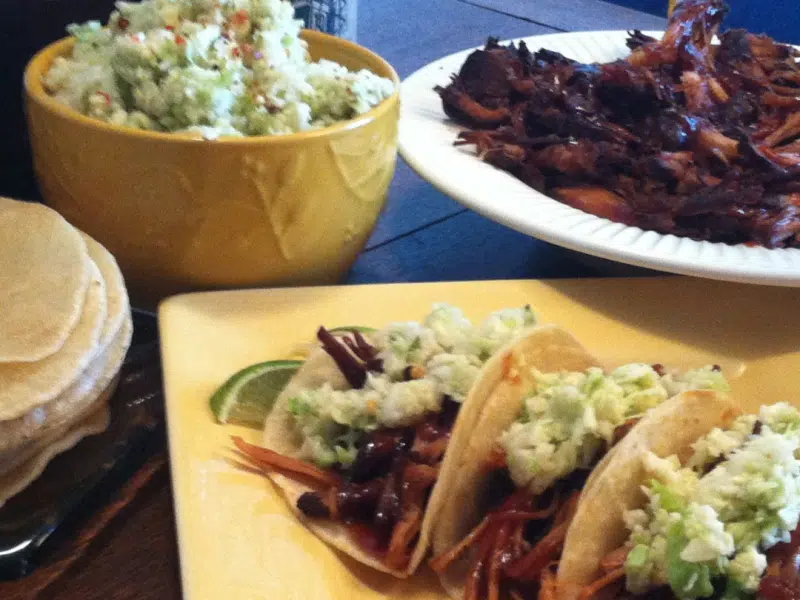 plate of Pulled Pork Tacos with slaw and a bowl of pulled pork